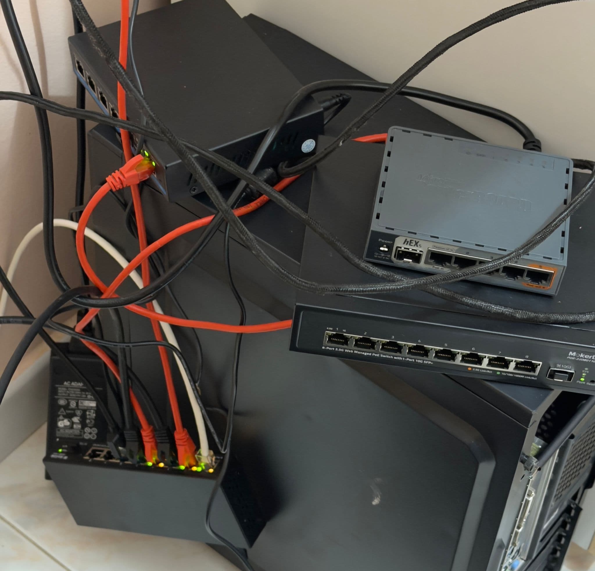 caos cavi homelab prima del DeskPi Rack Mate T2: MokerLink PoE switch e MikroTik HEX sovrapposti su scaffale